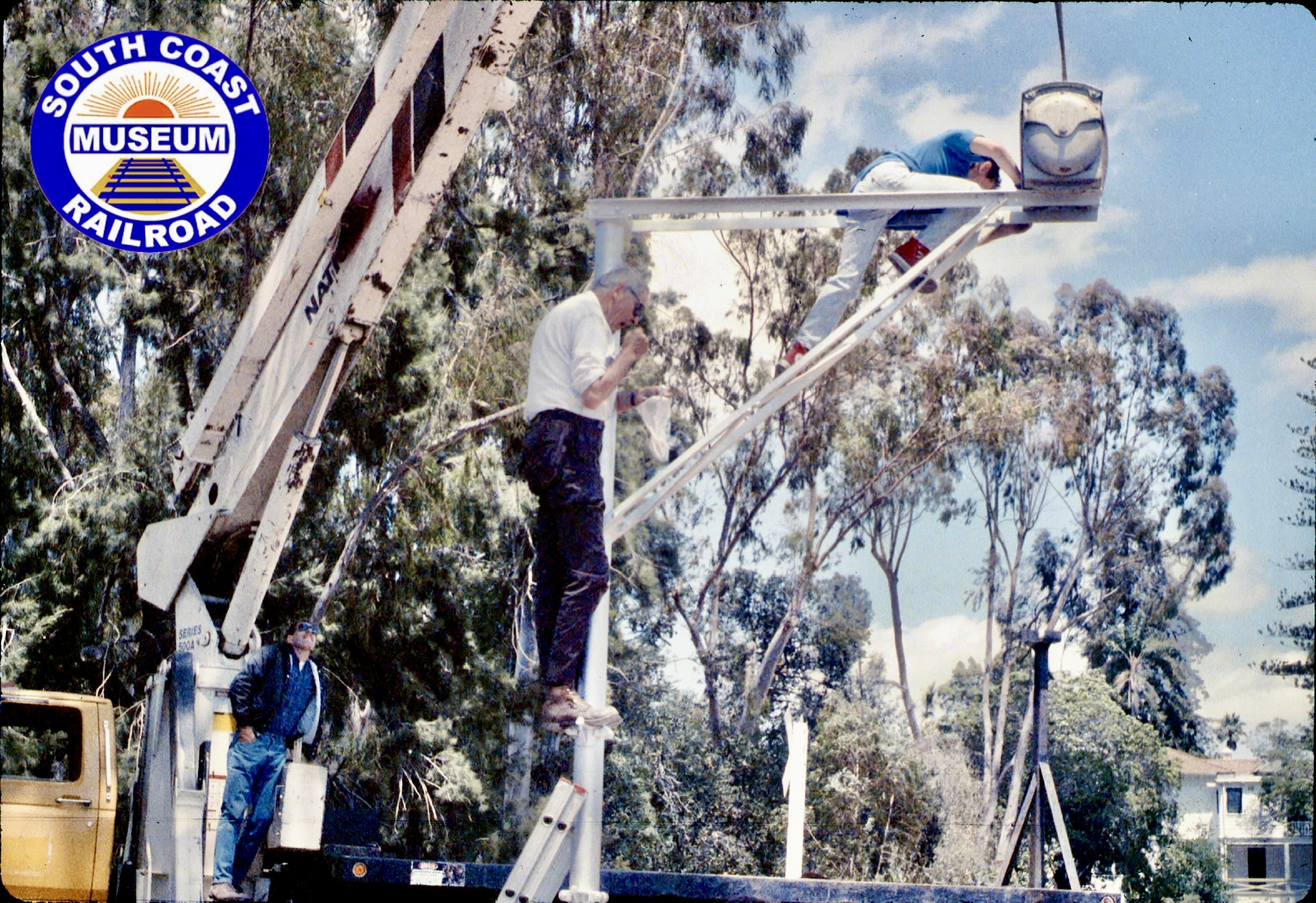 Picture of Seth Hammond, Gene Allen and Colin Hammond installing the wig-wag signal at the South Coast Railroad Museum in May of 1989.